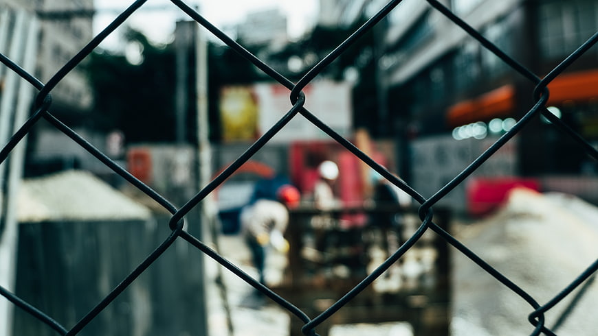 Chain link fence foreground with blurred construction site background
