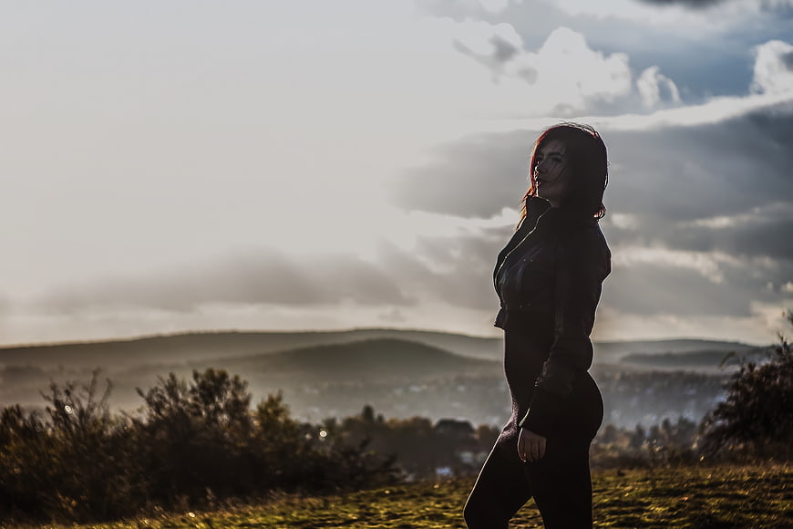 Silhouette of Woman Walking on Hilltop at Sunset