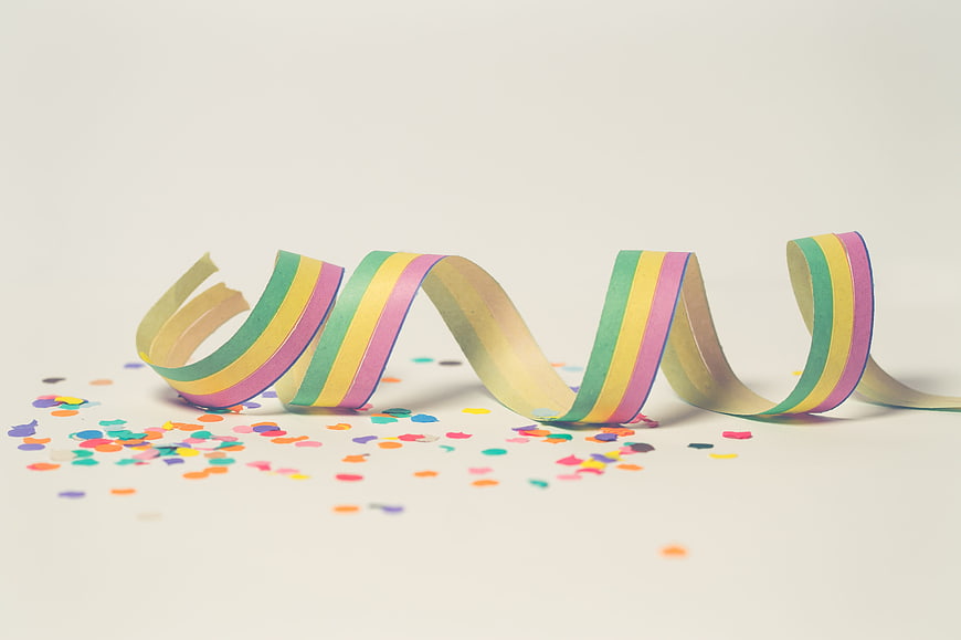 Colorful Paper Spiral Streamer and Confetti on White Background