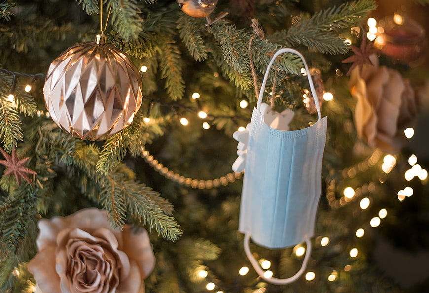 Blue surgical mask ornament on Christmas tree with lights