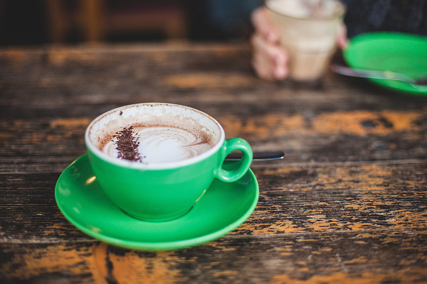 Green Cup of Cappuccino on Rustic Wooden Table