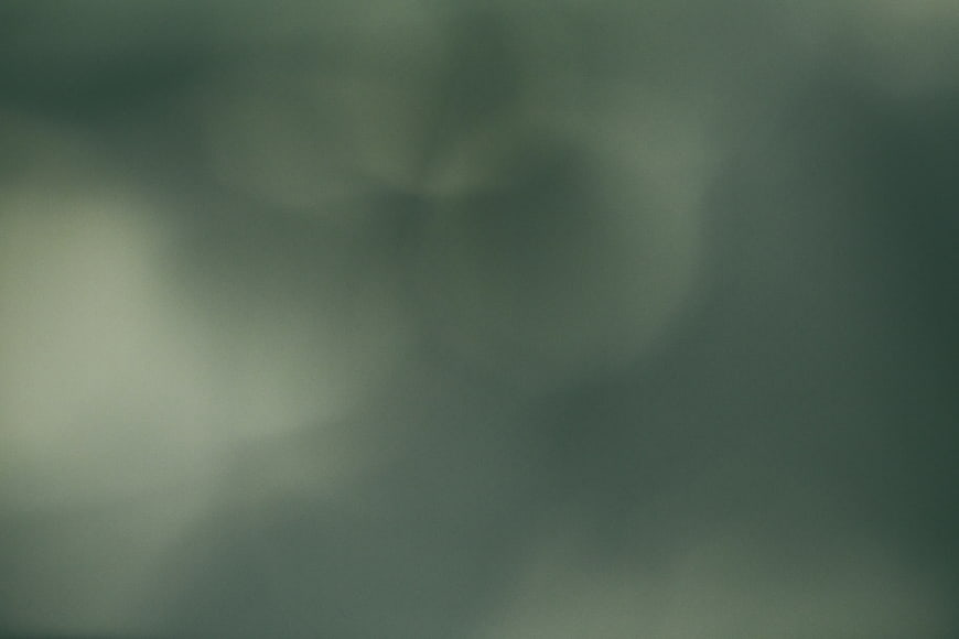 Abstract dark green bokeh background with soft glowing lights