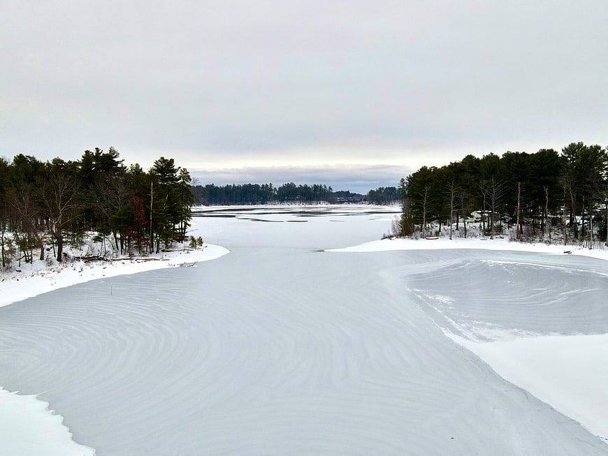 Aerial view of frozen lake with wind-swept snow patterns