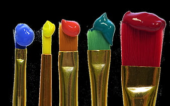 Five colorful paint brushes with gold ferrules on black background
