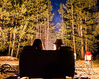 Couple Relaxing on Couch in Forest at Night