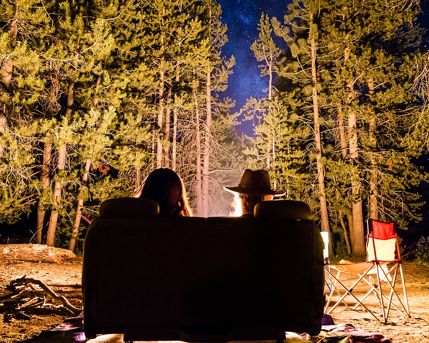 Couple Relaxing on Couch in Forest at Night