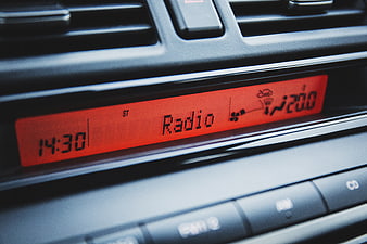Close-up of car dashboard radio display with red backlight
