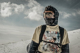 Snowboarder in winter gear standing on snowy mountain slope
