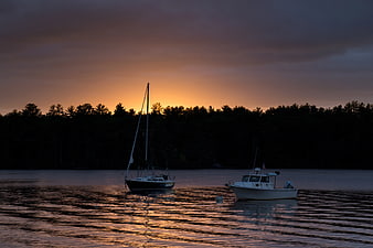 Sailboat and Motorboat Anchored at Sunset on Calm Lake
