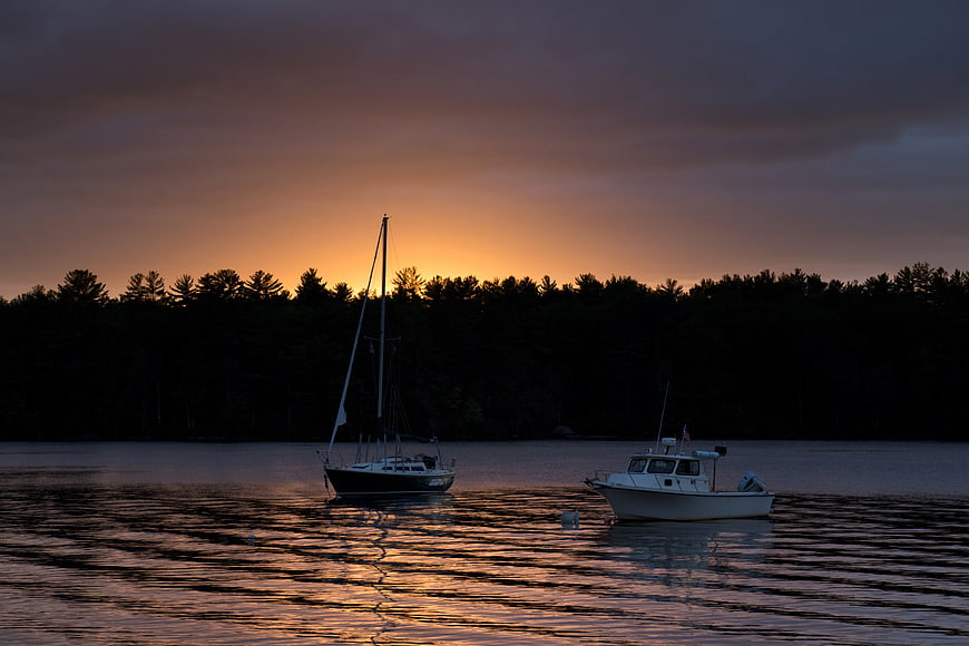 Sailboat and Motorboat Anchored at Sunset on Calm Lake