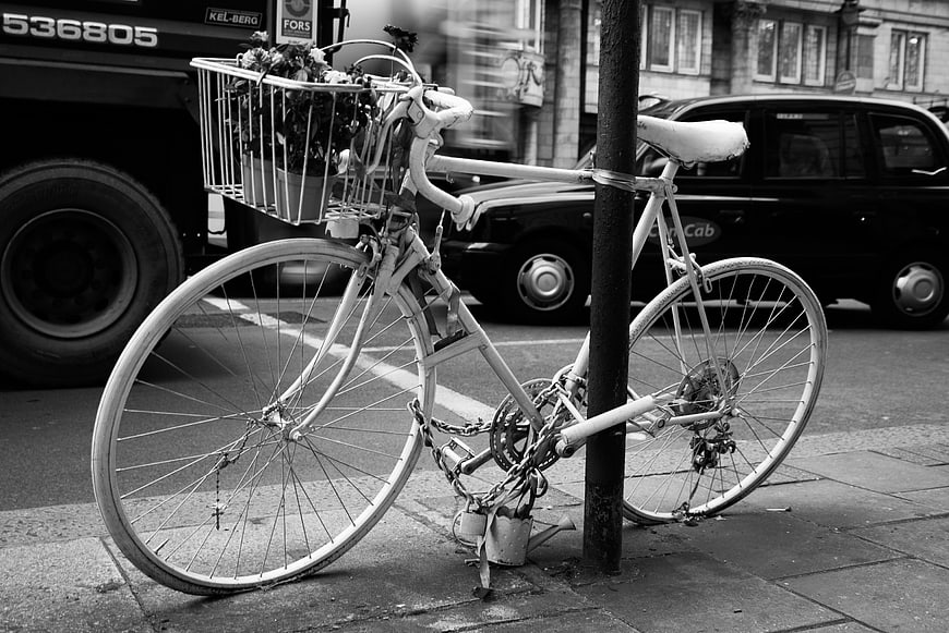 White bicycle with flowers locked to a post in London