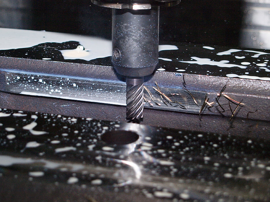 Close-up of CNC milling machine cutting metal with coolant spray