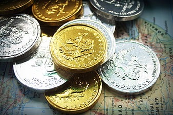 Gold and Silver Coins on World Map Background