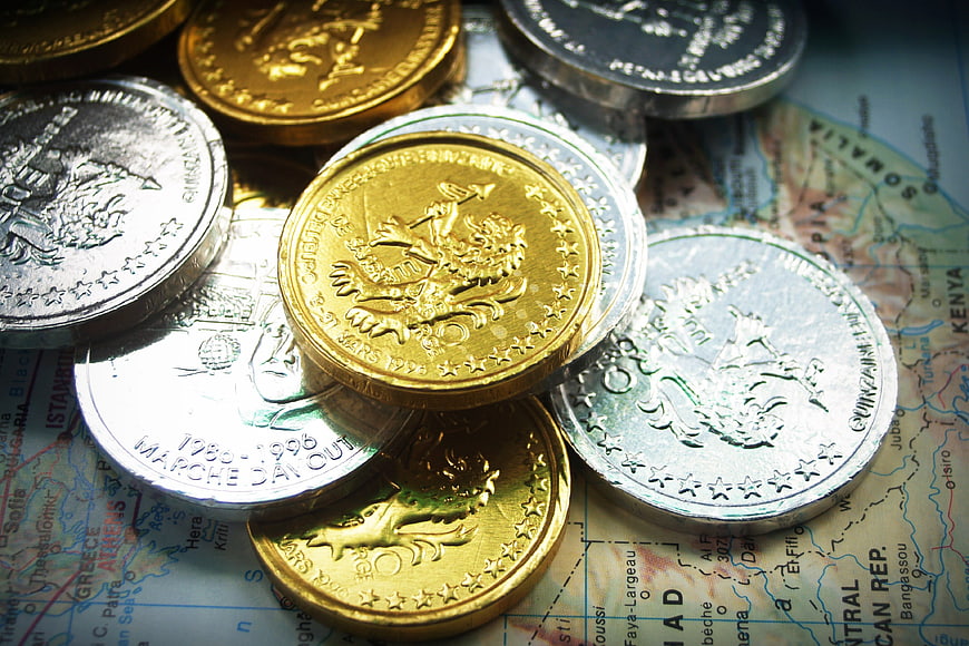 Gold and Silver Coins on World Map Background