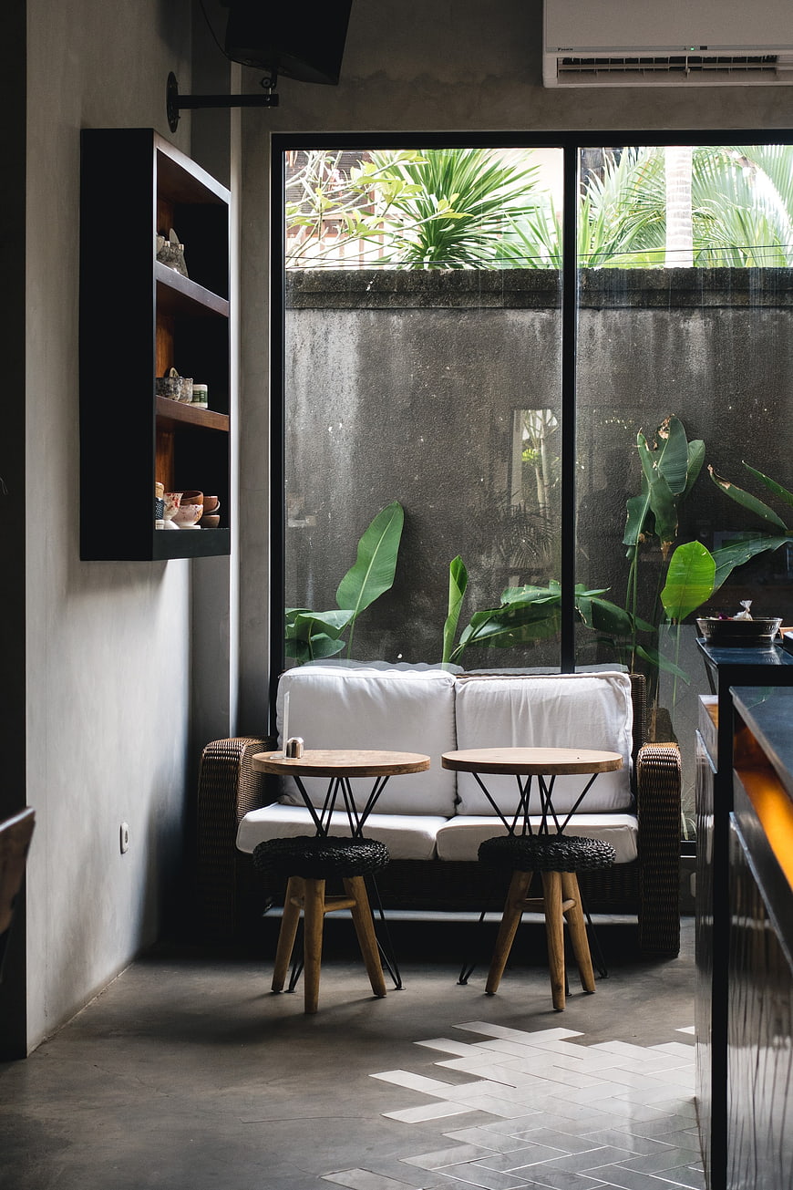 Modern minimalist cafe interior with white sofa and plants