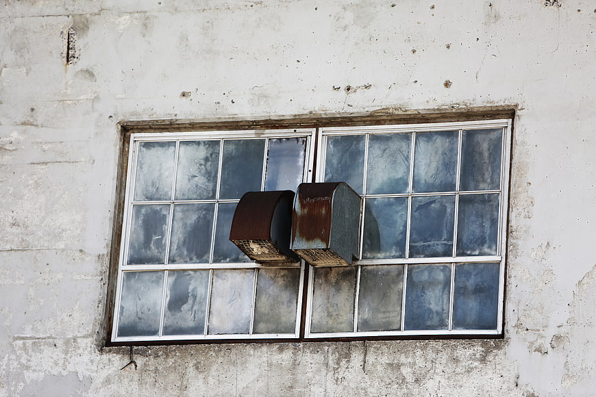 Rusty metal ventilation hoods on old window