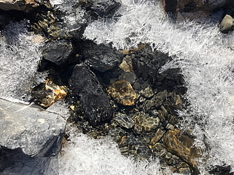Frozen stream with clear water and ice crystals on rocks