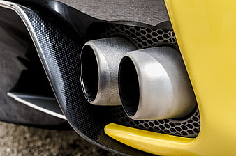 Close-up of dual exhaust pipes on a yellow sports car