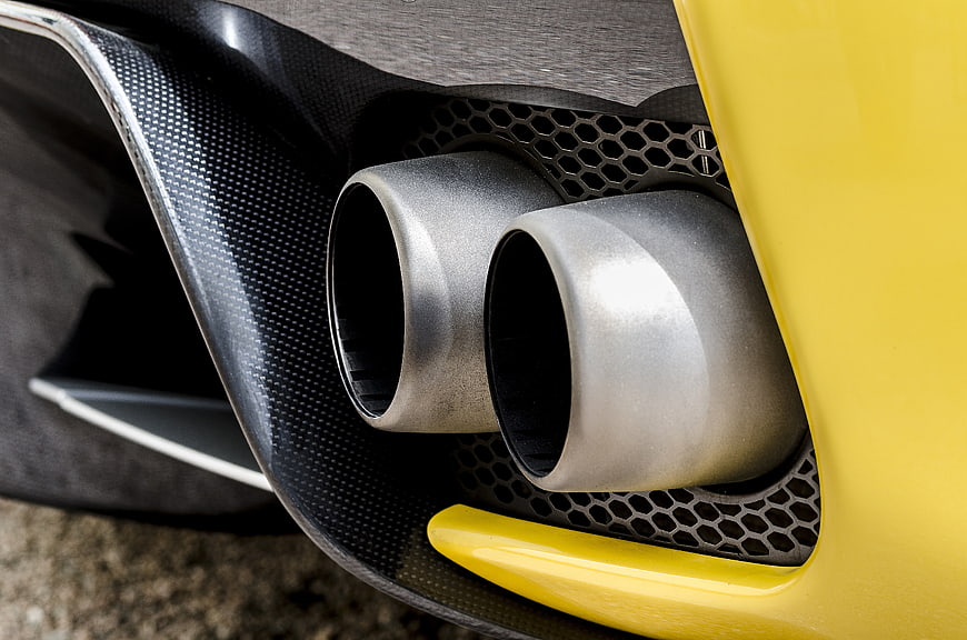 Close-up of dual exhaust pipes on a yellow sports car