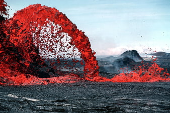 Dramatic volcanic eruption with glowing red lava fountain