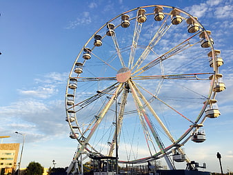 Large Ferris Wheel Against Blue Sky with Clouds