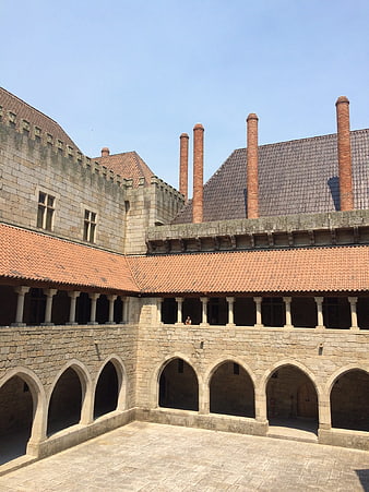 Historic stone courtyard with arches and chimneys in Braga, Portugal