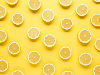 Top view of sliced lemons on a bright yellow background
