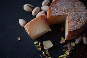 Artisanal Cheese Wedge with Pistachios on Dark Slate
