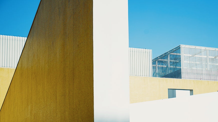 Modern architectural detail with yellow textured wall and blue sky