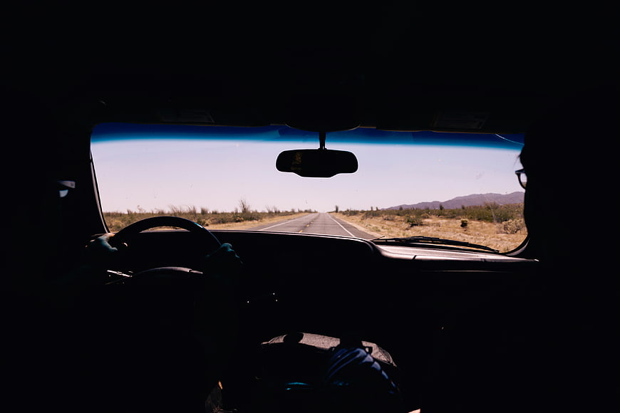 Silhouette of Couple Driving on Desert Highway