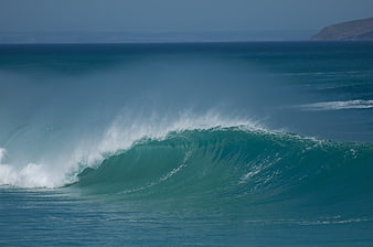 Powerful turquoise ocean wave crashing with white spray