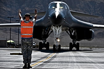 Military Aircraft Handler Directing B-1B Lancer Jet On Airfield