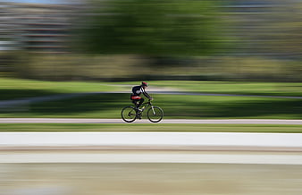 Cyclist Racing On Track With Motion Blur Background