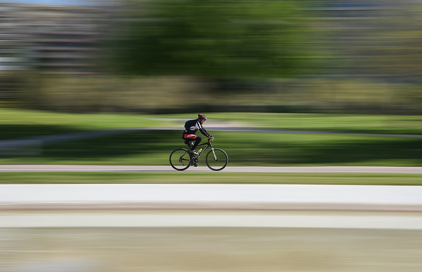 Cyclist Racing On Track With Motion Blur Background
