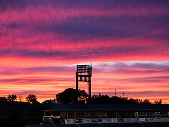 Vibrant Pink and Purple Sunset Over Baseball Stadium