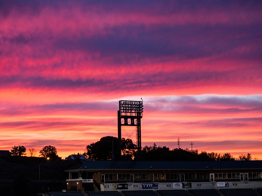 Vibrant Pink and Purple Sunset Over Baseball Stadium