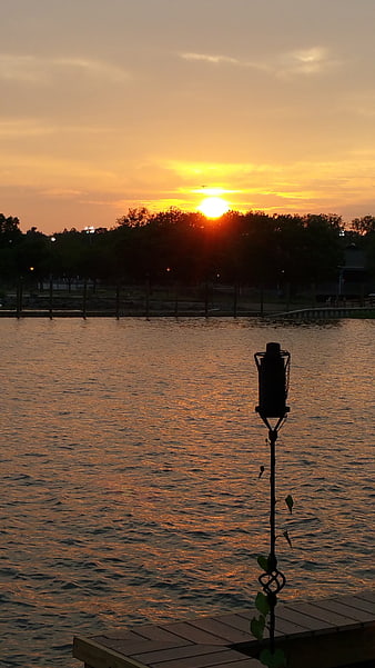 Sunset over Lake with Silhouette of Dock and Lamp