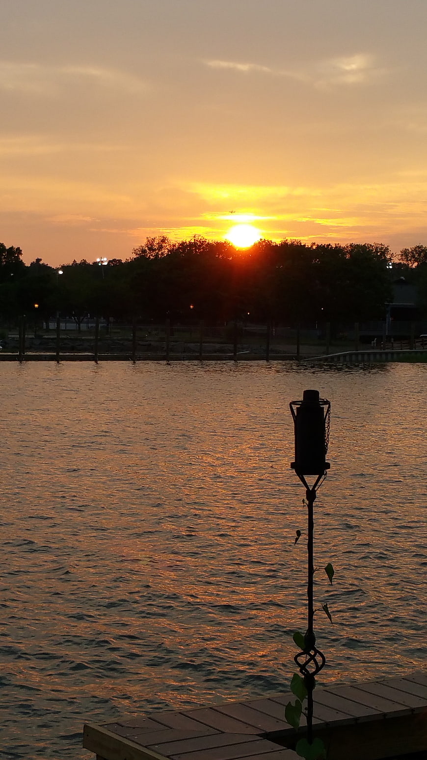 Sunset over Lake with Silhouette of Dock and Lamp
