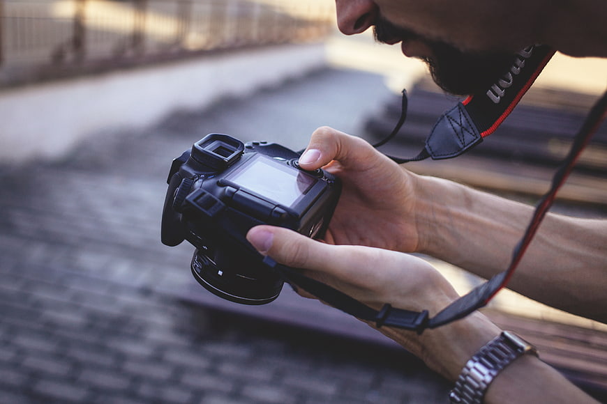 Close-up of photographer reviewing photos on DSLR camera