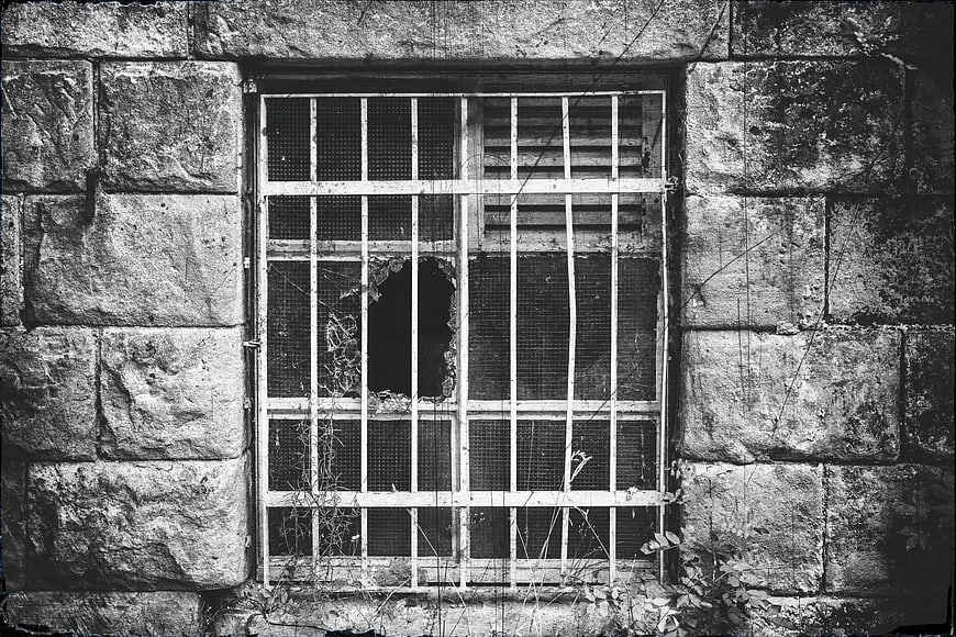 Barred Window In Weathered Stone Wall Black And White