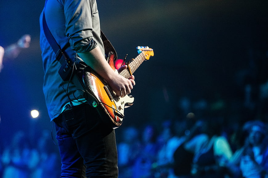 Guitarist Playing Electric Guitar on Stage at Night Concert
