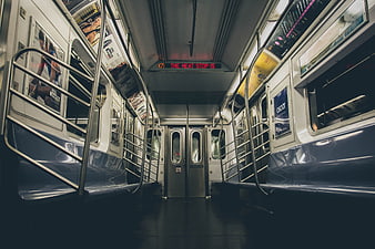 Empty subway car interior with blue seats and red digital display