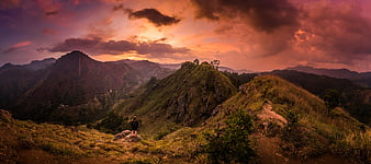Hiker on Mountain Ridge at Dramatic Sunset Panorama