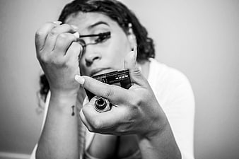Woman applying mascara in black and white close-up