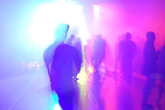 Silhouetted Crowd Dancing in Neon Purple and Blue Club Lights