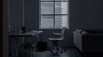 Dark moody office interior with desk and window