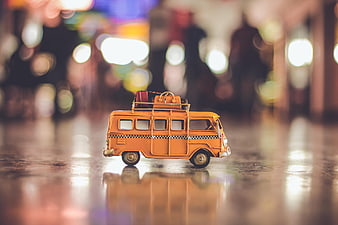 Vintage orange toy bus with luggage on roof rack