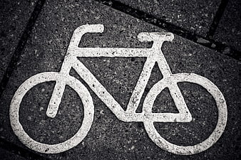 White Bicycle Symbol Painted on Dark Asphalt Pavement