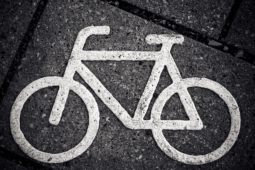 White Bicycle Symbol Painted on Dark Asphalt Pavement