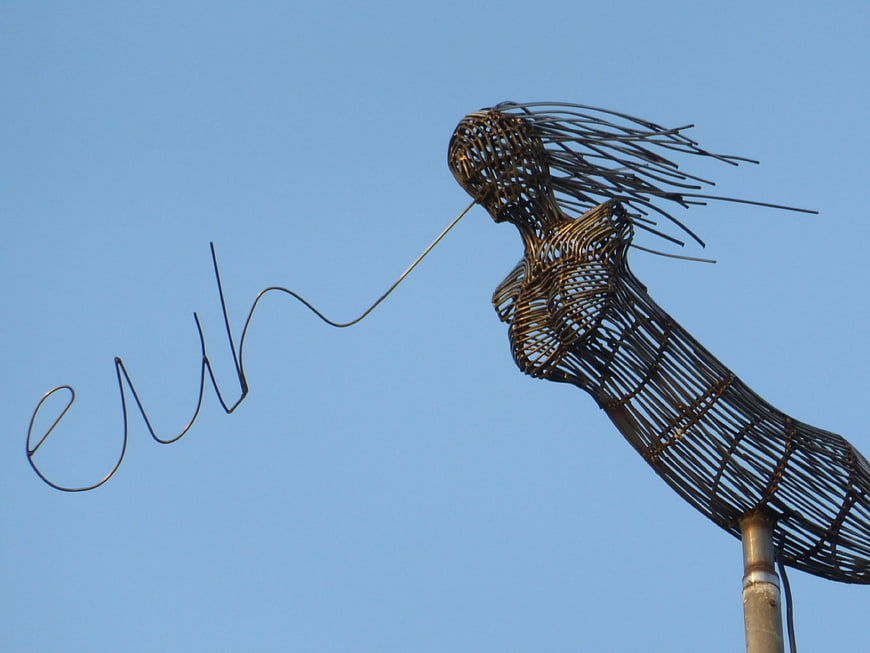 Metal wire mermaid sculpture against blue sky